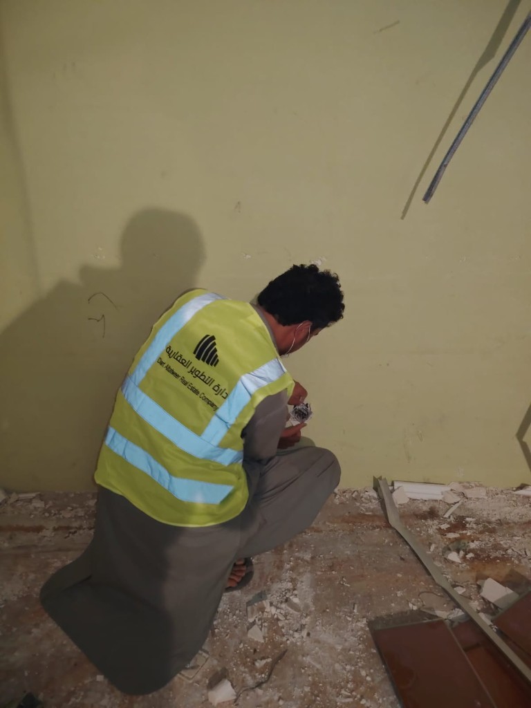 قبل أن يُسلَّم المفتاح: إدارة أملاك في مرحلة تجهيز الوحدة فني دارة التطوير يعدّل مخرجاً كهربائياً قرب الأرض وسط مخلفات تشطيب ضمن إدارة أملاك