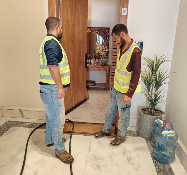 فريق إدارة أملاك من دارة التطوير أثناء إشراف ميداني وصيانة في ممر مجمع سكني فاخر بالرياض